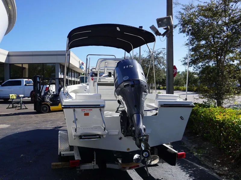 Slide: The Image of 2024 Parker 1801CC boat with outboard motor, parked outdoors under a canopy. - 11