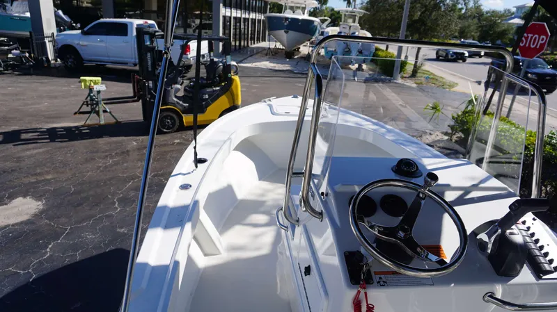 Slide: The Image of 2024 Parker 1801CC boat with steering console, parked outdoors near vehicles and equipment. - 12