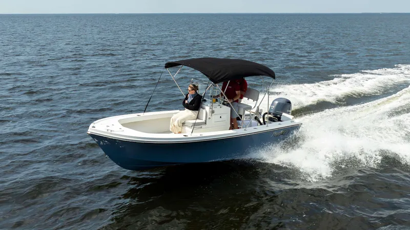 Slide: The Image of 2024 Parker 1801CC boat cruising on open water with passengers under a canopy. - 3