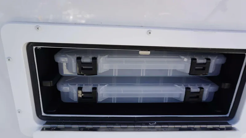 Slide: The Image of Storage compartment with two clear plastic boxes in a 2024 Parker 1801CC boat. - 9