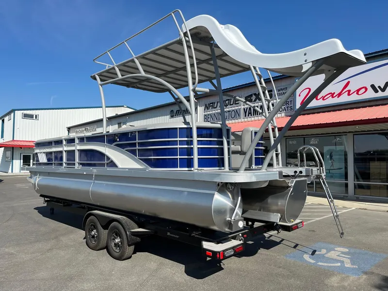 Slide: The Image of 2023 Bennington 25LSRTDSP pontoon boat with slide, parked on a trailer outside a dealership. - 10