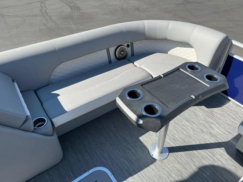 Slide: The Image of 2023 Bennington 25LSRTDSP boat interior with gray seating and cupholder table. - 18
