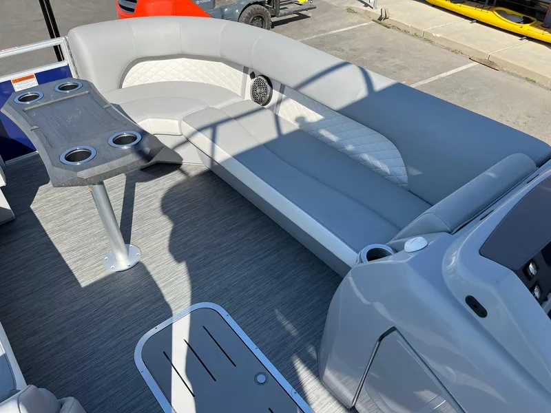 Slide: The Image of 2023 Bennington 25LSRTDSP boat interior with gray seating and table, featuring cup holders. - 19