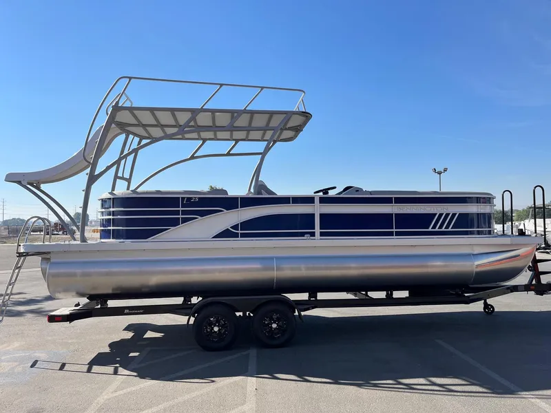 Slide: The Image of 2023 Bennington 25LSRTDSP pontoon boat with upper deck, parked on trailer. - 7