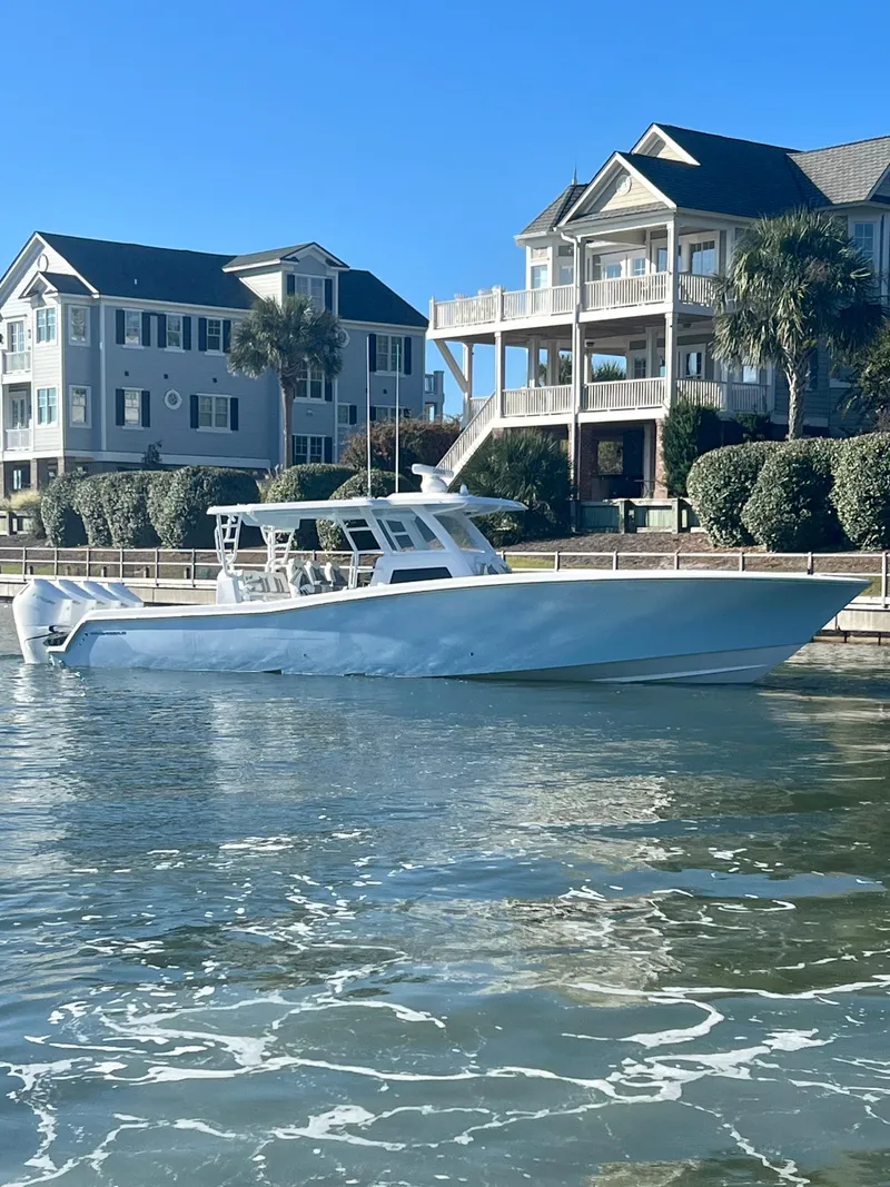 Slide: The Image of 2024 Invincible 43 Open Fisherman boat docked near waterfront homes. - 1