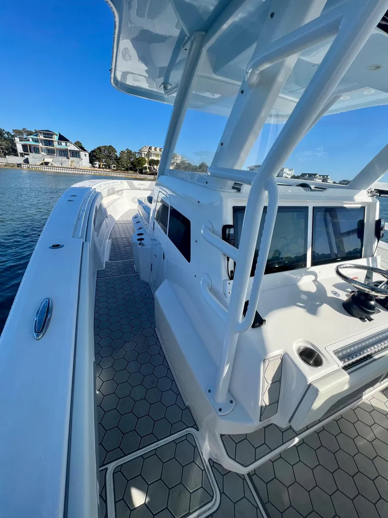 Slide: The Image of 2024 Invincible 43 Open Fisherman boat docked by waterfront homes. - 13