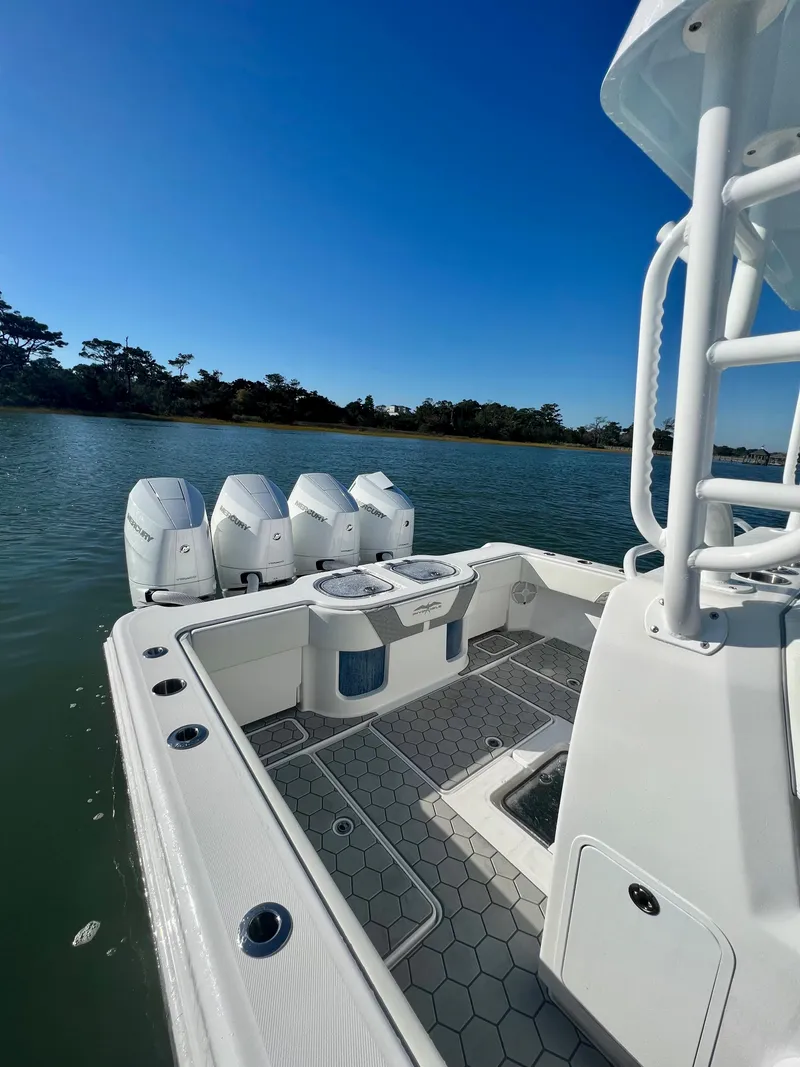 Slide: The Image of 2024 Invincible 43 Open Fisherman boat with quad outboard engines on a calm lake. - 16