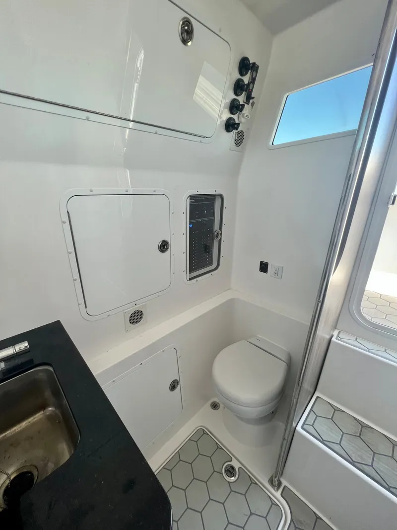Slide: The Image of 2024 Invincible 43 Open Fisherman boat interior with toilet, sink, and storage compartments. - 23
