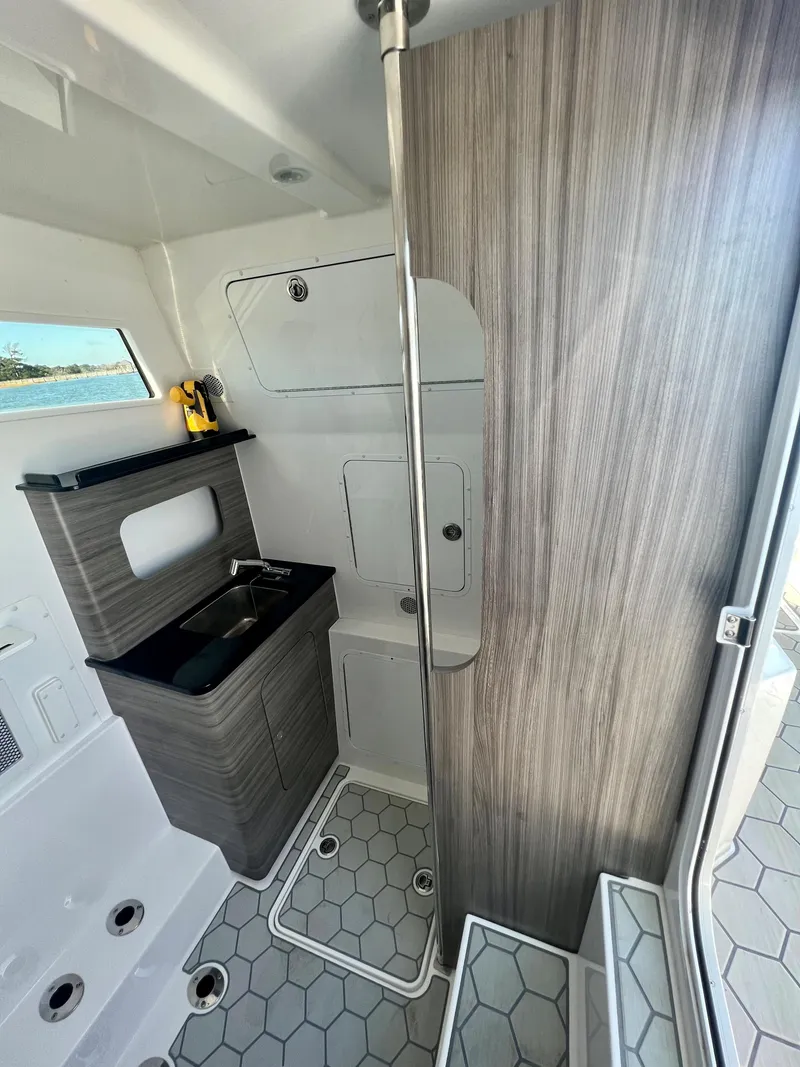 Slide: The Image of 2024 Invincible 43 Open Fisherman interior with modern design and hexagonal flooring. - 24