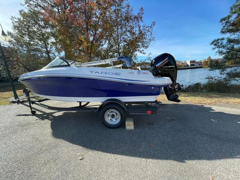 Slide: The Image of 2024 Tahoe 185 S boat on trailer by a lake. - 3