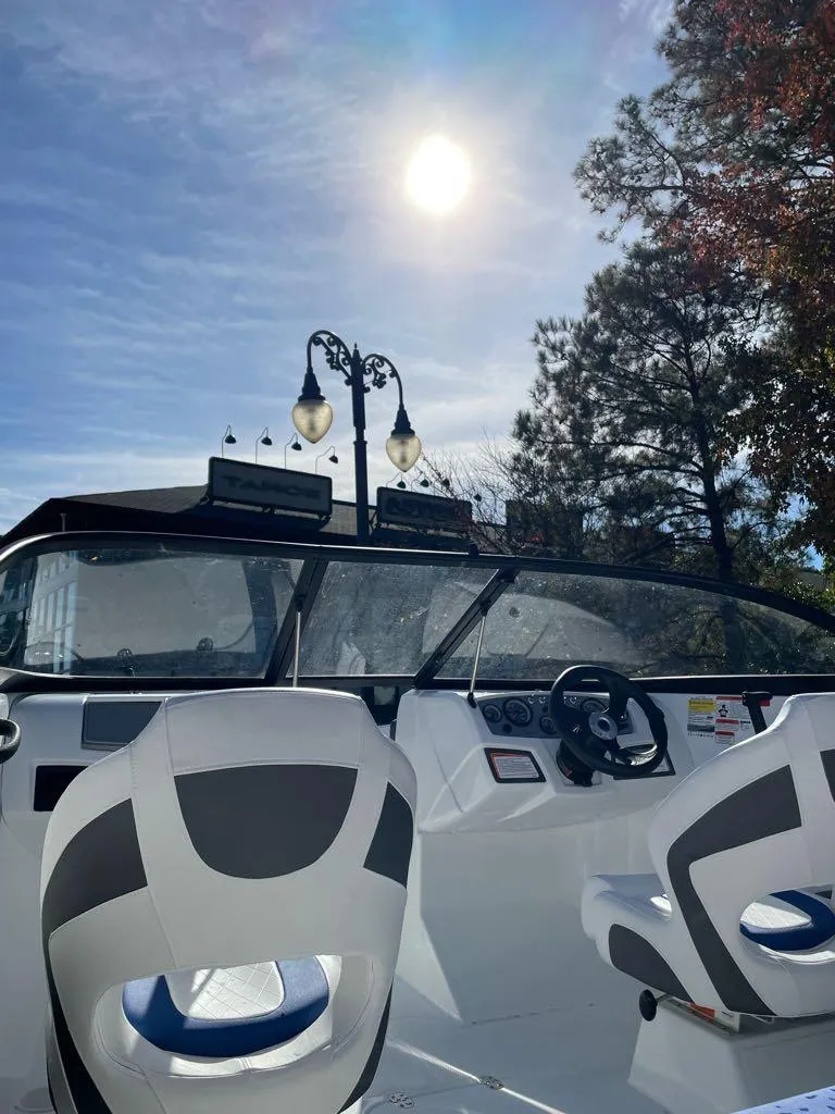 Slide: The Image of 2024 Tahoe 185 S boat interior under sunny sky with trees in the background. - 4