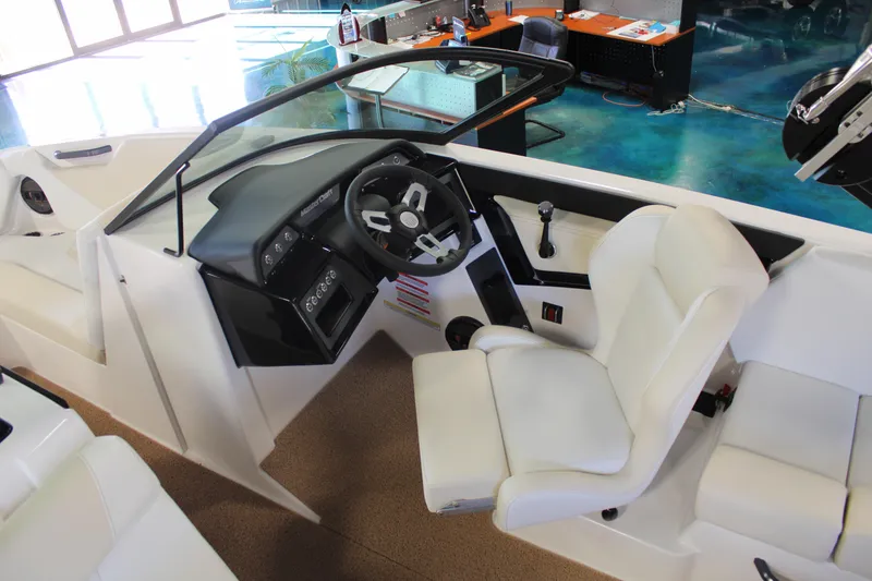 Slide: The Image of 2024 MasterCraft NXT22 boat interior with steering wheel and white seating. - 13