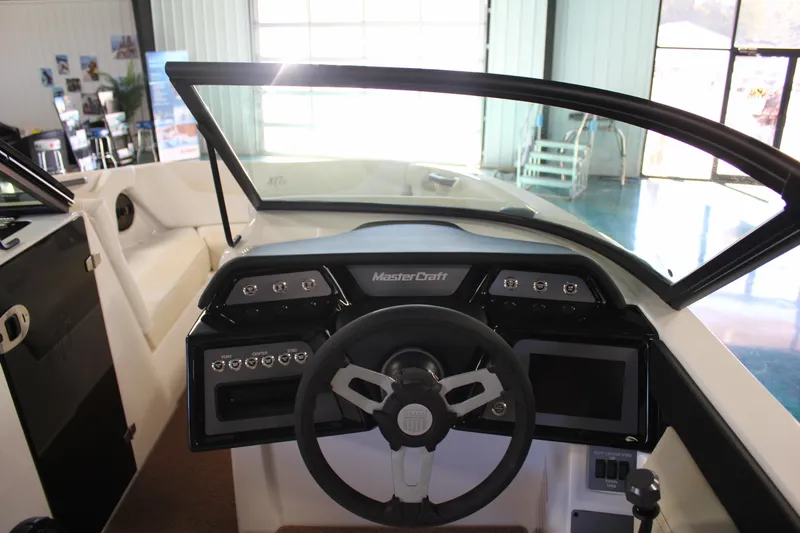 Slide: The Image of 2024 MasterCraft NXT22 boat dashboard with steering wheel and control panels. - 14