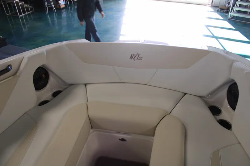 Slide: The Image of 2024 MasterCraft NXT22 boat interior with beige seating and cup holders. - 8