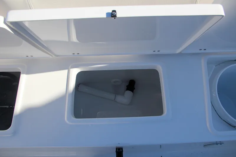 Slide: The Image of 2024 Sea Hunt Ultra 229 storage compartment with plumbing. - 18