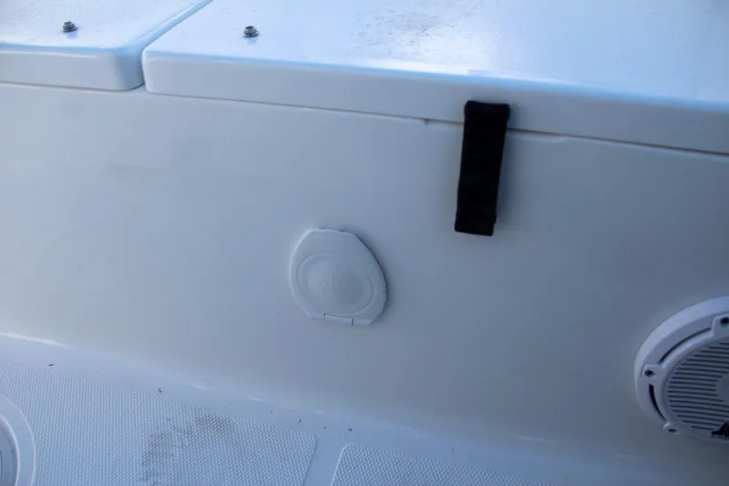 Slide: The Image of 2024 Sea Hunt Ultra 229 boat interior detail with storage compartment and speaker. - 22