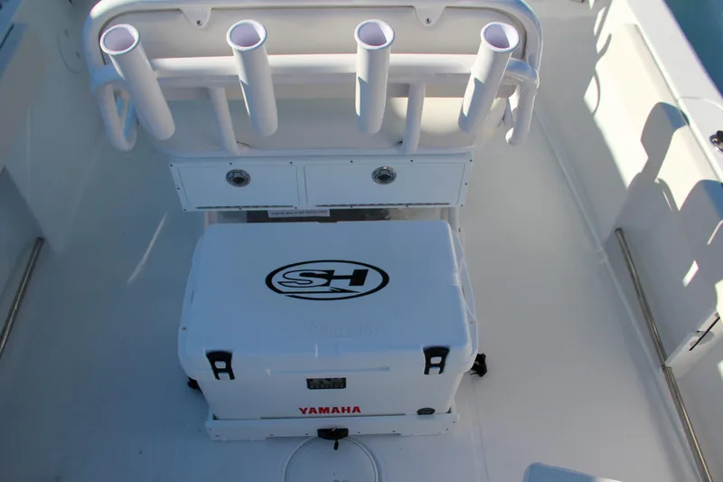 Slide: The Image of 2024 Sea Hunt Ultra 229 boat interior with rod holders and Yamaha cooler. - 29