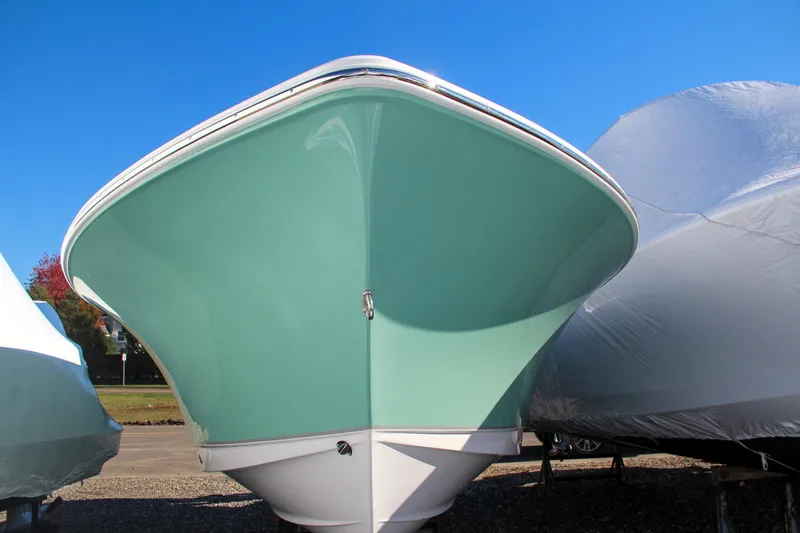 Slide: The Image of 2024 Sea Hunt Ultra 229 boat front view, light blue hull, parked on land. - 3