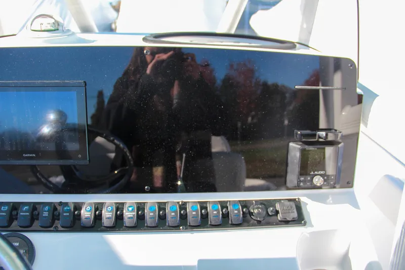 Slide: The Image of Control panel of 2024 Sea Hunt Ultra 229 boat with switches and display. - 41