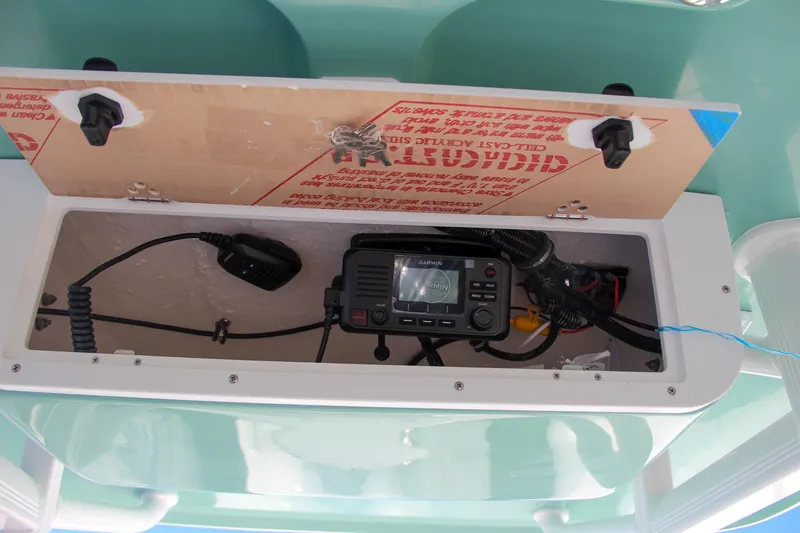 Slide: The Image of 2024 Sea Hunt Ultra 229 boat electronics compartment with radio and microphone. - 45