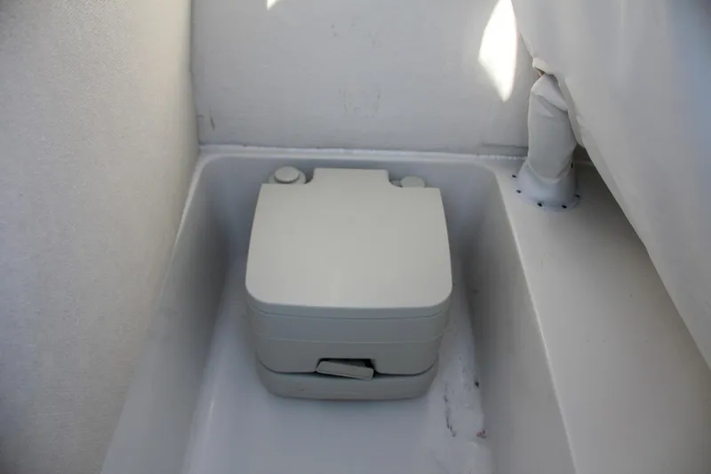 Slide: The Image of Portable toilet in the 2024 Sea Hunt Ultra 229 boat. - 48