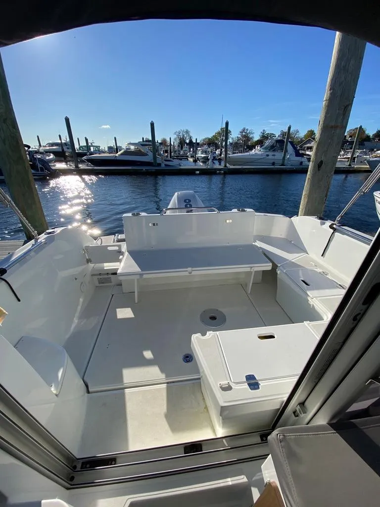 Slide: The Image of 2021 Beneteau Antares 23 boat docked at a marina, featuring a spacious deck. - 11