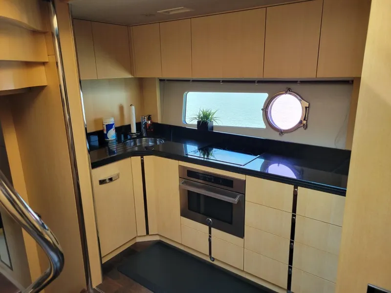 Slide: The Image of Modern kitchen interior of 2014 Sunseeker 68 Predator yacht with sleek cabinetry and porthole window. - 19