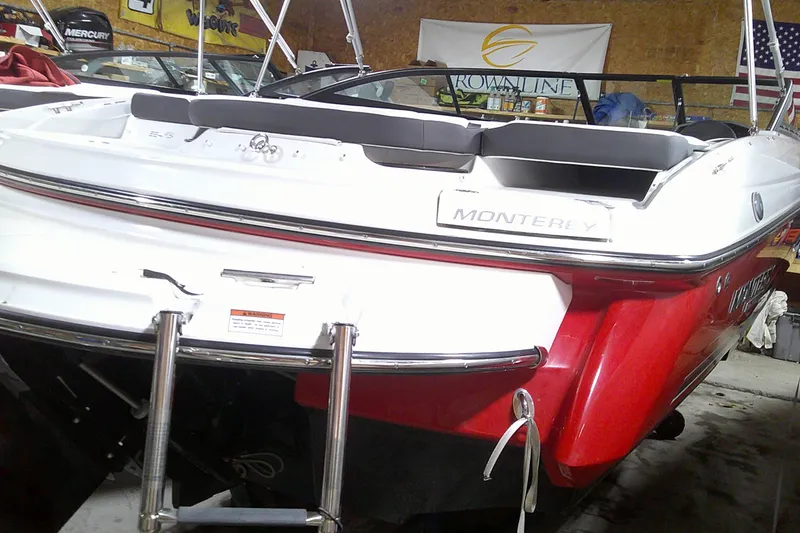 Slide: The Image of 2023 Monterey 224FS boat, red and white, rear view in a showroom. - 13