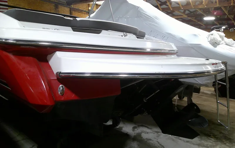 Slide: The Image of 2023 Monterey 224FS boat in storage, rear view with swim platform and ladder. - 14
