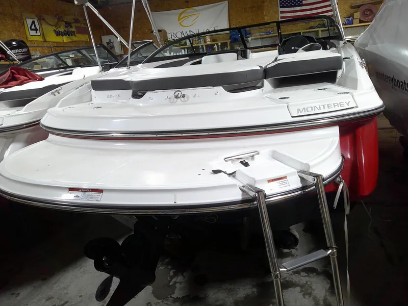 Slide: The Image of 2023 Monterey 224FS boat in showroom, rear view with swim platform and ladder. - 15