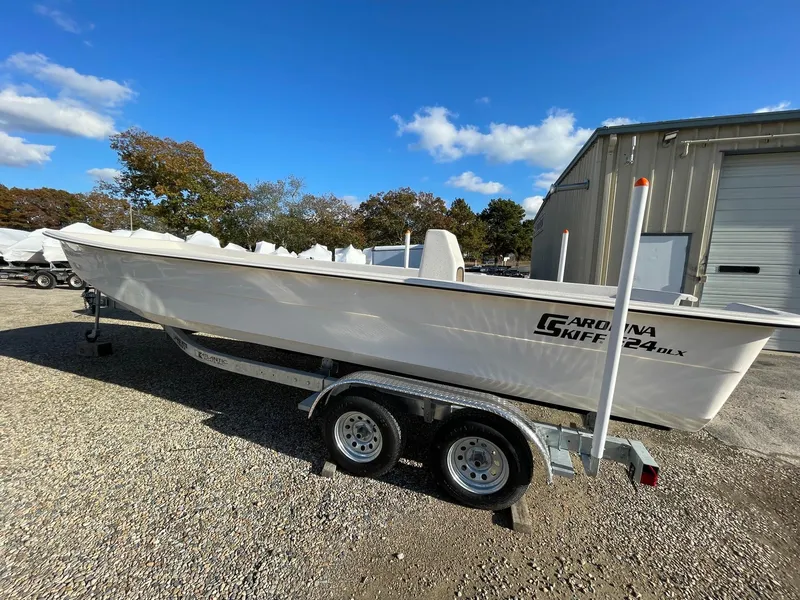 The Image of 2024 Carolina Skiff e24 dlx boat on trailer outside storage facility. - 0