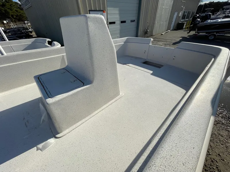 Slide: The Image of 2024 Carolina Skiff e24 DLX boat deck with seating and storage compartment. - 5
