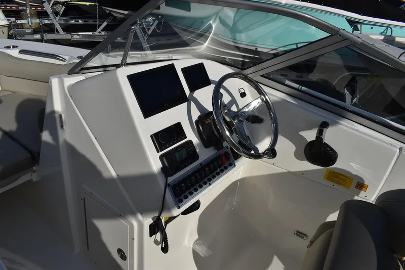 Slide: The Image of 2024 Key West 239 DFS boat dashboard with steering wheel and control panel. - 44