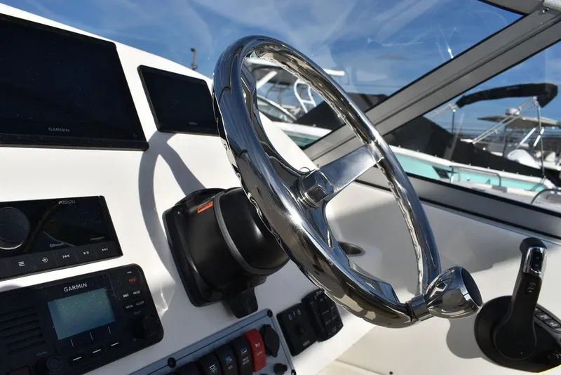 Slide: The Image of Steering wheel of 2024 Key West 239 DFS boat with control panel and navigation equipment. - 49