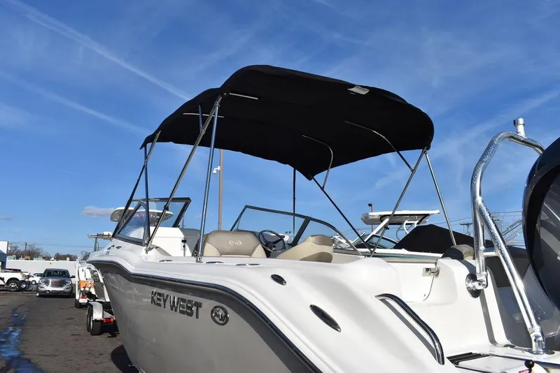 Slide: The Image of 2024 Key West 239 DFS boat with canopy, parked outdoors under blue sky. - 5