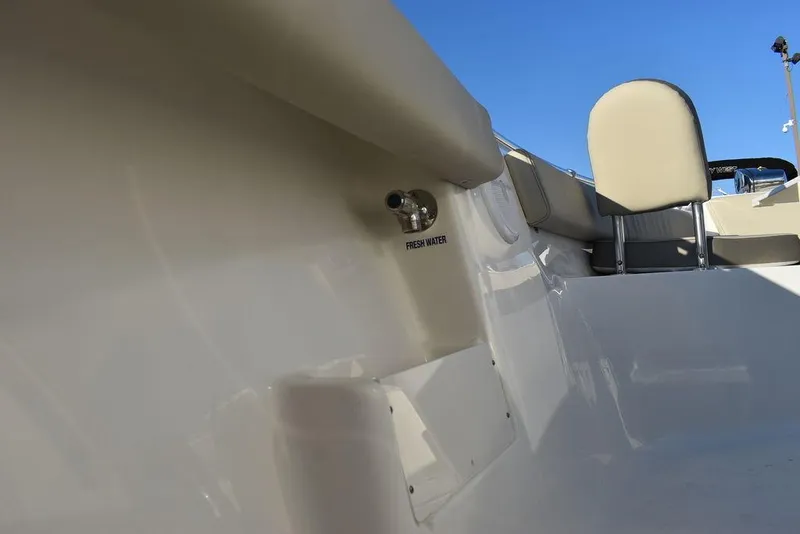 Slide: The Image of 2024 Key West 239 FS boat interior with fresh water feature, beige seating, and clear blue sky. - 32