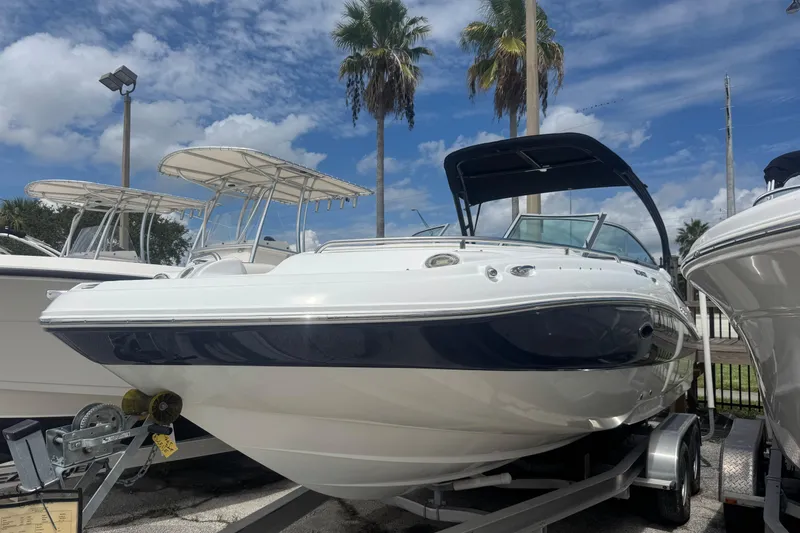 Slide: The Image of 2018 Hurricane SD 2400 I/O boat on trailer under clear sky with palm trees. - 0