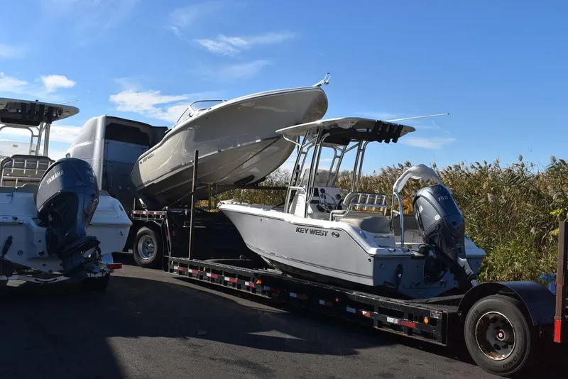 The Image of 2024 Key West 203 FS boat on trailer, ready for transport under clear blue sky. - 1