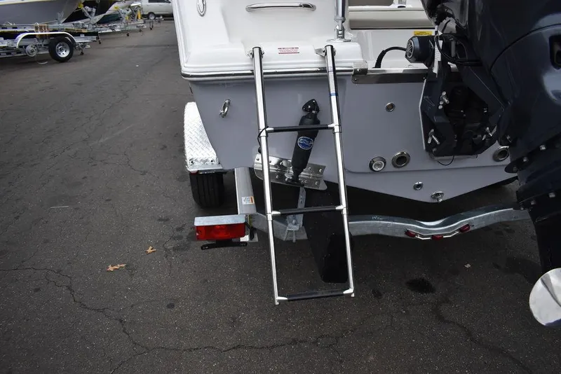Slide: The Image of 2024 Key West 203 FS boat rear view with ladder and motor on trailer. - 20