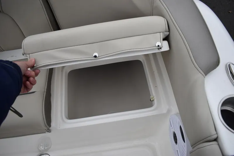 Slide: The Image of 2024 Key West 203 FS boat seat storage compartment with beige upholstery. - 25