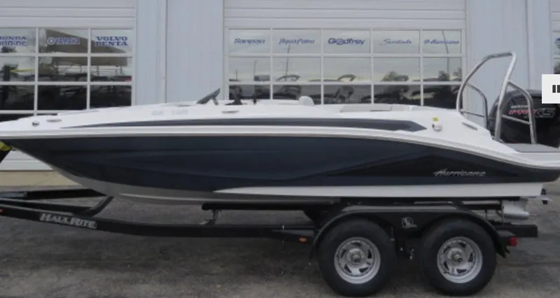 Slide: The Image of 2023 Hurricane SunDeck 185 OB boat on a trailer in front of a dealership. - 1