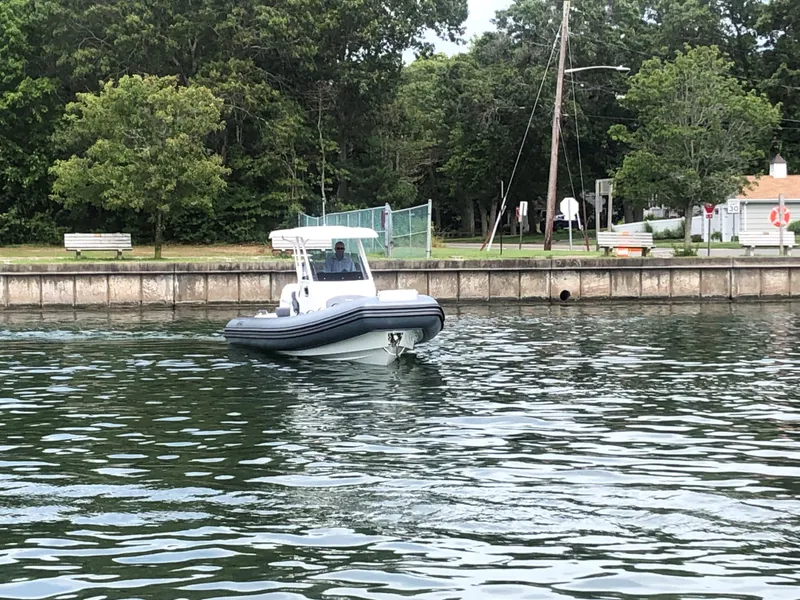 Slide: The Image of 2024 Brig Eagle 8 boat cruising near a dock with trees in the background. - 12