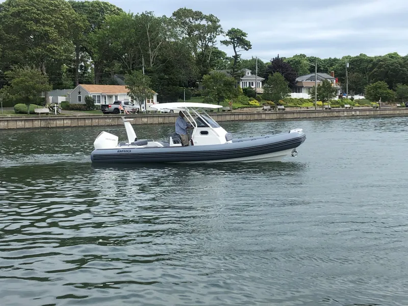 Slide: The Image of 2024 Brig Eagle 8 boat on calm water near residential shoreline. - 16