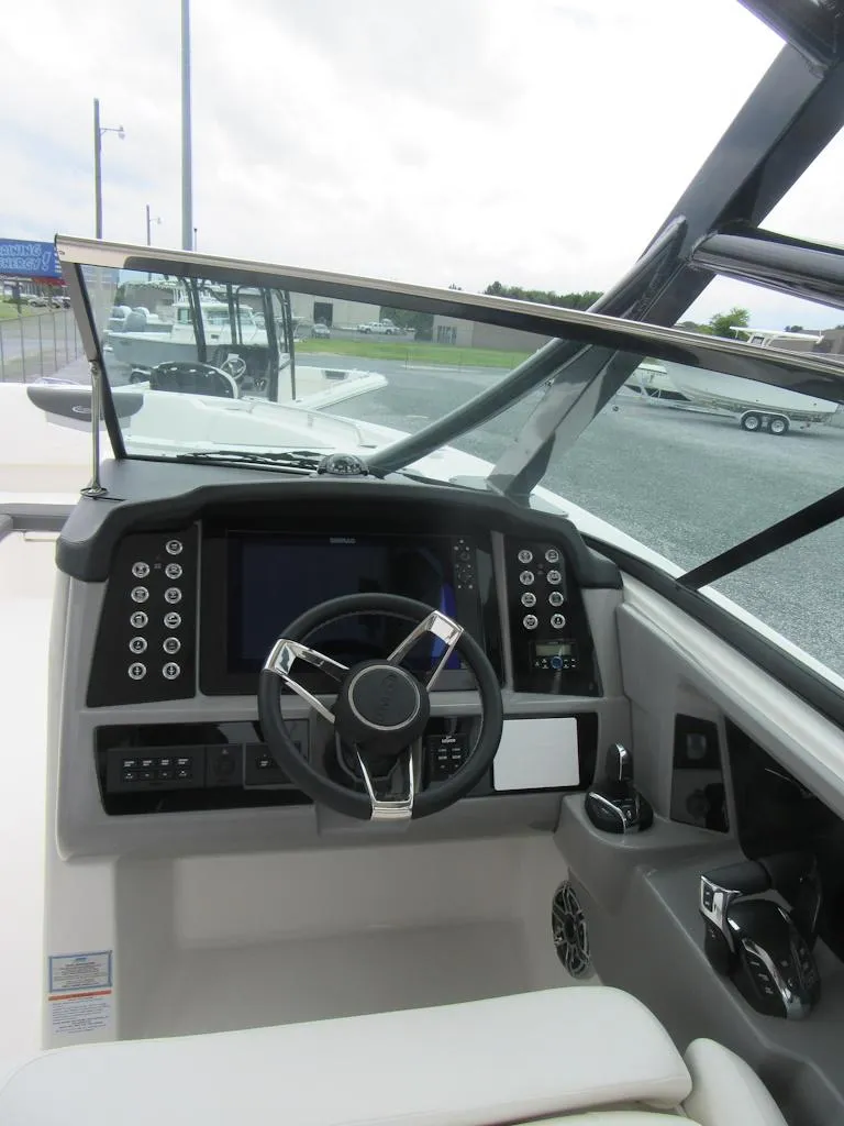 Slide: The Image of 2024 Robalo R317 Dual Console boat cockpit with modern steering and dashboard controls. - 17
