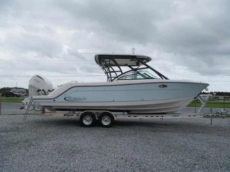 The Image of 2024 Robalo R317 Dual Console boat on trailer, overcast sky background. - 2