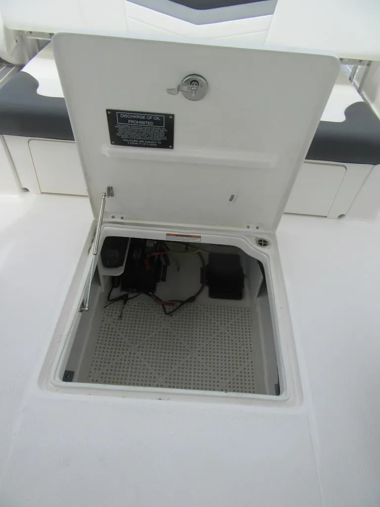 Slide: The Image of 2024 Robalo R317 Dual Console storage compartment with open hatch. - 30