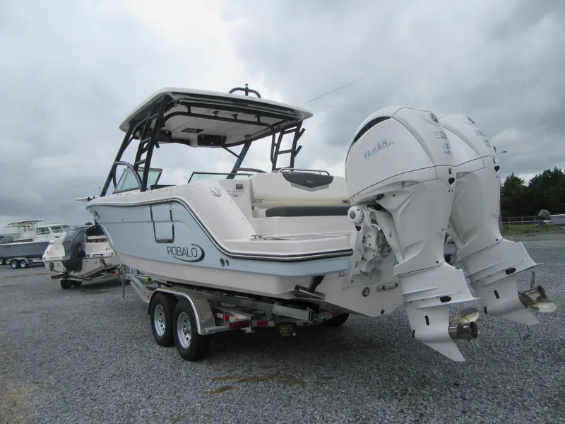 Slide: The Image of 2024 Robalo R317 Dual Console boat on trailer, featuring twin engines. - 4