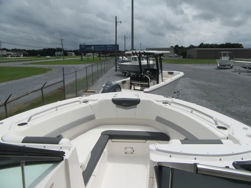 Slide: The Image of 2024 Robalo R317 Dual Console boat with spacious seating, parked outdoors. - 6