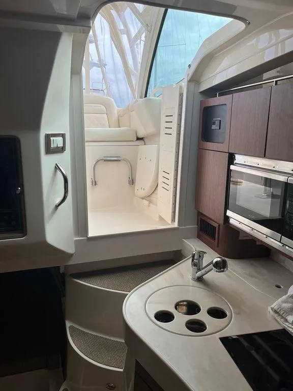 Slide: The Image of Interior of 2020 Grady-White 330 Express boat with kitchenette and steps to cockpit. - 10