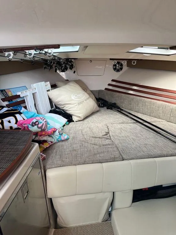 Slide: The Image of Interior cabin of 2020 Grady-White 330 Express boat with bed and fishing rods. - 11